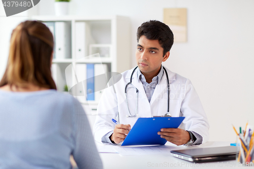 Image of doctor with clipboard and patient at hospital