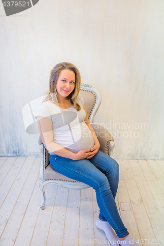 Image of Beautiful pregnant woman sitting