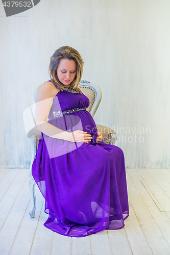 Image of Beautiful pregnant woman sitting