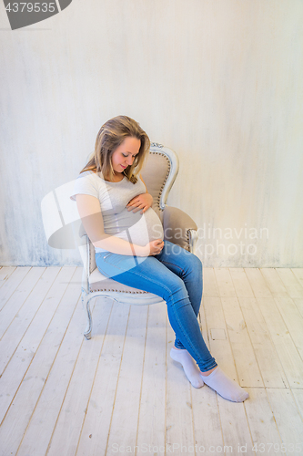 Image of Young pregnant woman sitting