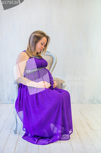 Image of Beautiful pregnant woman sitting
