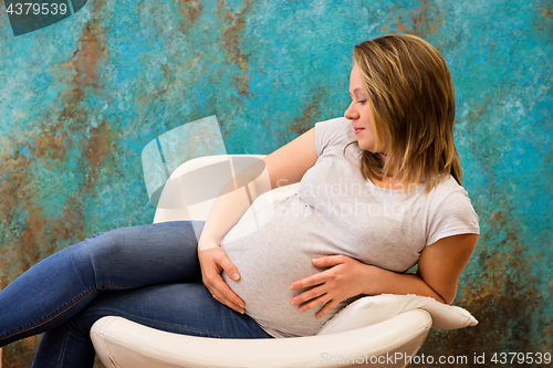 Image of Young pregnant woman sitting