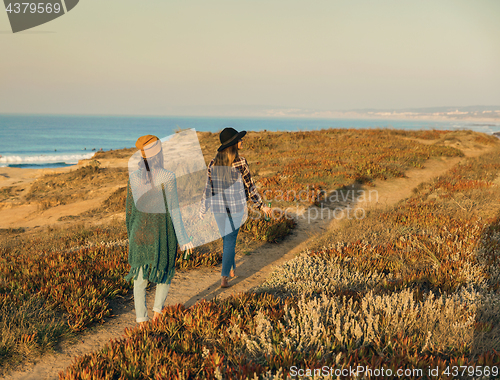 Image of Girs walking ove the coastline