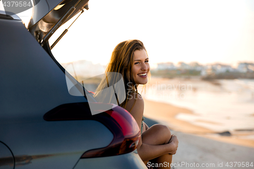 Image of Girl near the beach sitting on the car