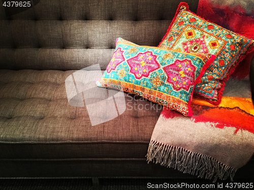 Image of Textile sofa decorated with bright ornate cushions