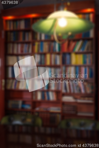 Image of Defocused image of bookcase and green lamp