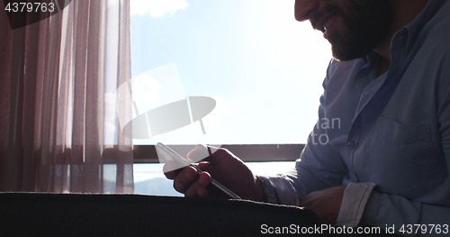 Image of Business Man Talking On Cell Phone At Home