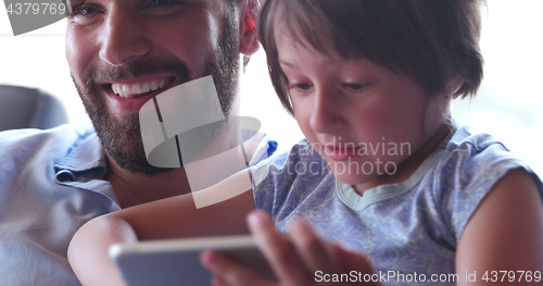 Image of Father Daughter using Tablet in modern apartment