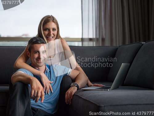 Image of Attractive Couple Using A Laptop on couch