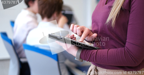 Image of Pretty Businesswoman Using Tablet In Office Building during conf