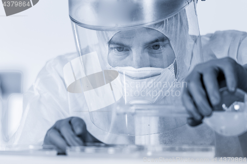 Image of Life scientist researching in bio hazard laboratory. High degree of protection work.