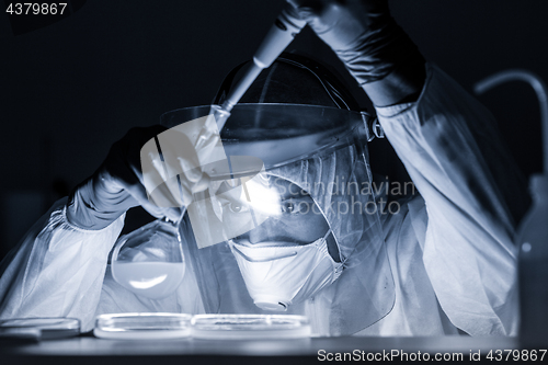 Image of Life scientist researching in bio hazard laboratory. High degree of protection work.