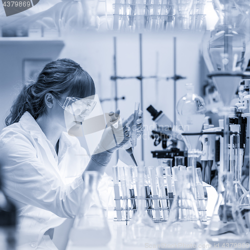 Image of Young scientist pipetting in life science laboratory.