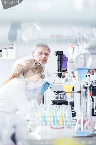 Image of Health care researchers microscoping in scientific laboratory.