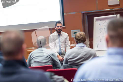 Image of Skiled Businessman Presenting a Project to His Work Team at Informal Company Meeting.