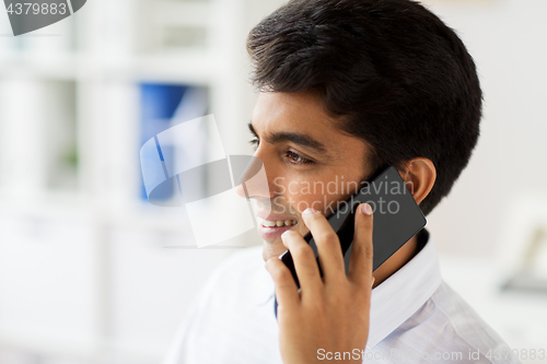 Image of businessman calling on smartphone at office