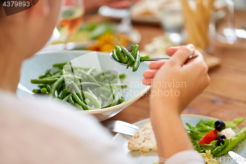 Image of close up of woman eating green beans