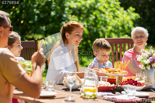 Image of happy family having dinner or summer garden party