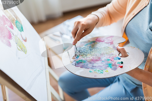 Image of artist with palette knife painting at art studio