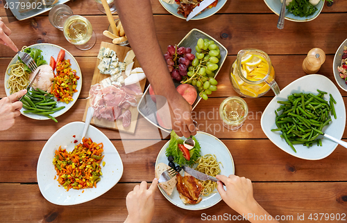 Image of group of people eating at table with food
