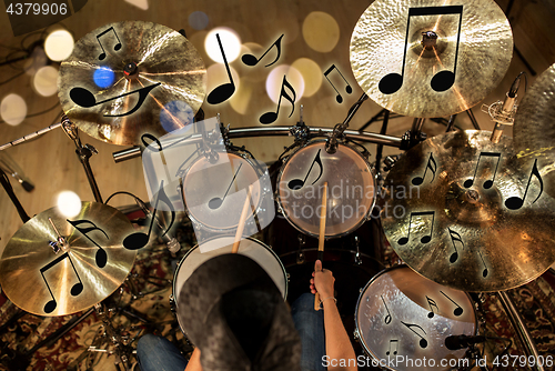 Image of male musician playing drum kit at concert