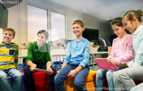 Image of group of happy children with tablet pc at school