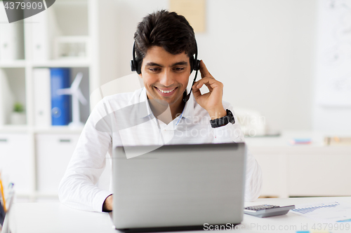Image of businessman with headset and laptop at office