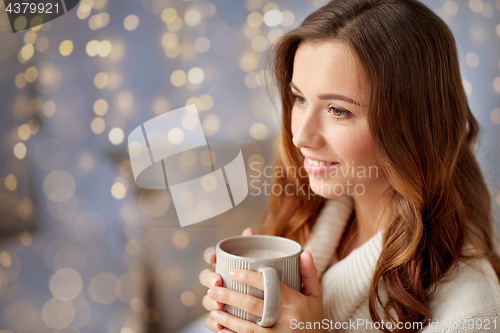 Image of happy woman with cup of cocoa or coffee at home