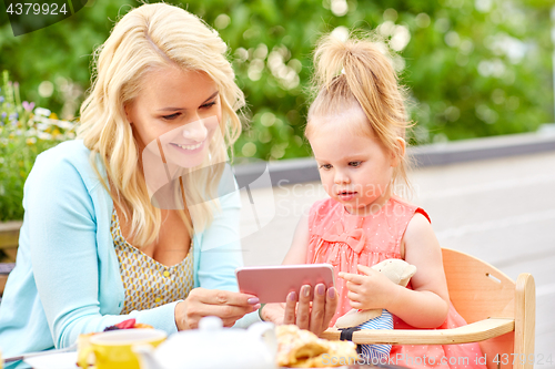 Image of mother and daughter with smartphone at cafe