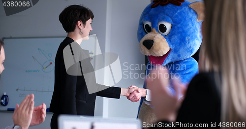 Image of boss dresed as bear having fun with business people in trendy of