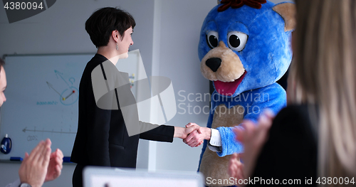 Image of boss dresed as bear having fun with business people in trendy of