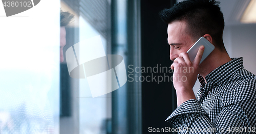 Image of Business Man Talking On Cell Phone, Looking Out Office Window