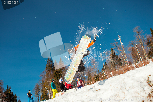 Image of Bukovel, Ukraine - December 22, 2016: Man boarder jumping on his snowboard against the backdrop of mountains, hills and forests in the distance. Bukovel, Carpathian mountains