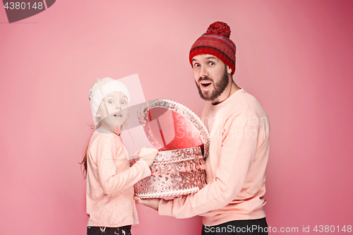 Image of Portrait of a surprised little girl with her father holding a Christmas present