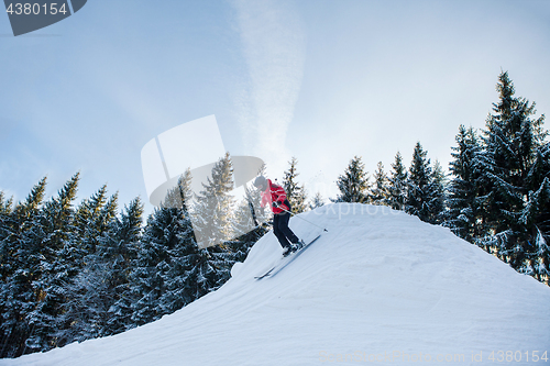 Image of Full length shot of a woman skiing in the mountains