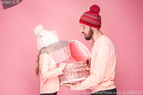 Image of Portrait of a surprised little girl with her father holding a Christmas present