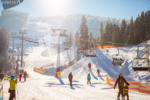 Image of Bukovel, Ukraine - December 22, 2016: Skiers on the ski lift riding up at ski resort with beautiful background of snow-covered slopes, forests, hills in Bukovel, Ukraine