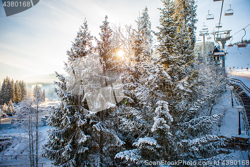 Image of Skiers on the ski lift riding up at ski resort with beautiful background of snow-covered slopes, forests, hills in Bukovel, Ukraine