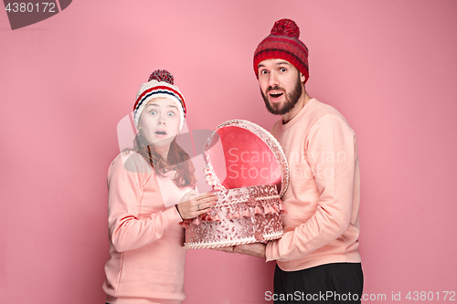 Image of Portrait of a surprised little girl with her father holding a Christmas present