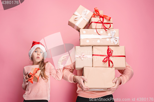 Image of Portrait of a surprised little girl with her father holding a Christmas present