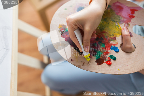 Image of artist applying paint to palette at art studio