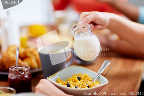 Image of hands of woman eating cereals for breakfast