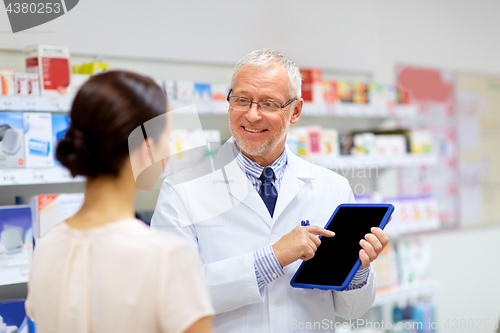 Image of apothecary and customer with tablet pc at pharmacy