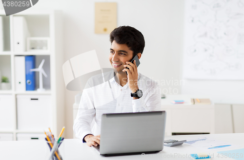 Image of businessman calling on smartphone at office