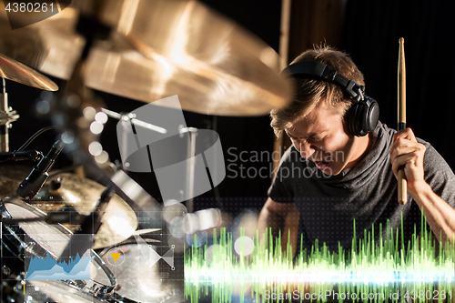 Image of male musician playing drum kit at concert