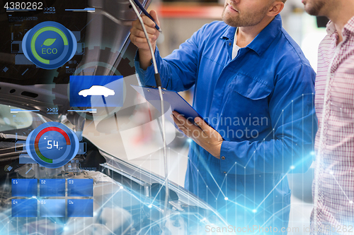Image of auto mechanic with clipboard and man at car shop