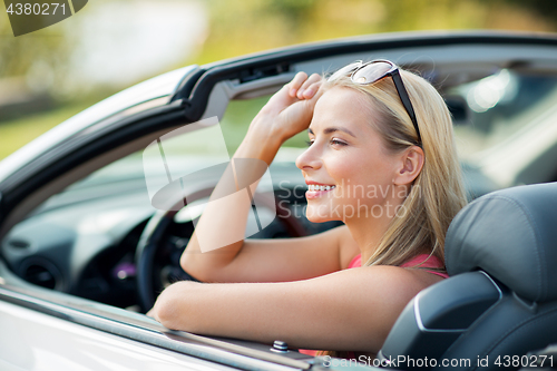 Image of happy young woman in convertible car