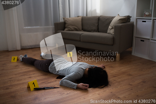 Image of dead woman body lying on floor at crime scene