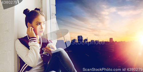 Image of teenage girl with smartphone and earphones