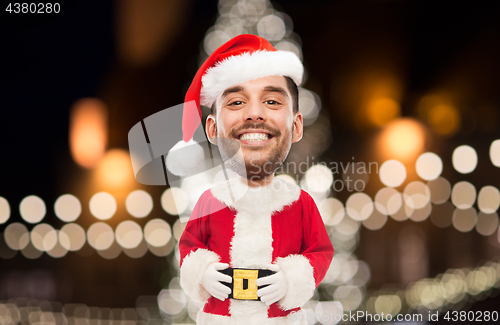 Image of man in santa claus costume over christmas lights